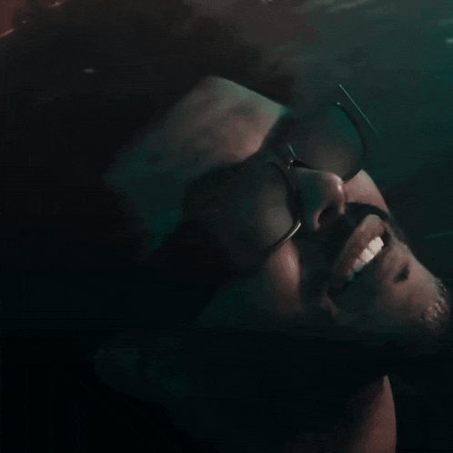 a man wearing glasses and a beard is swimming in the water