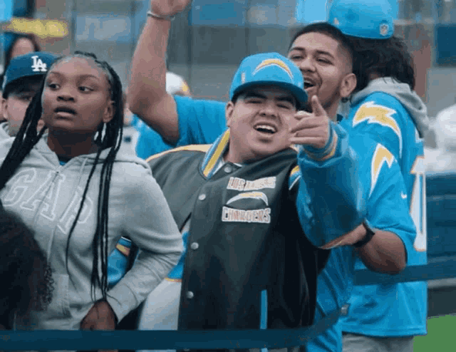 a man wearing a jacket that says los angeles chargers is pointing