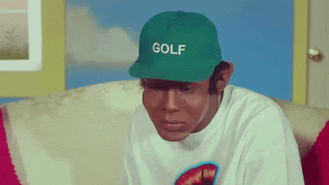 a man wearing a white shirt and a green golf hat