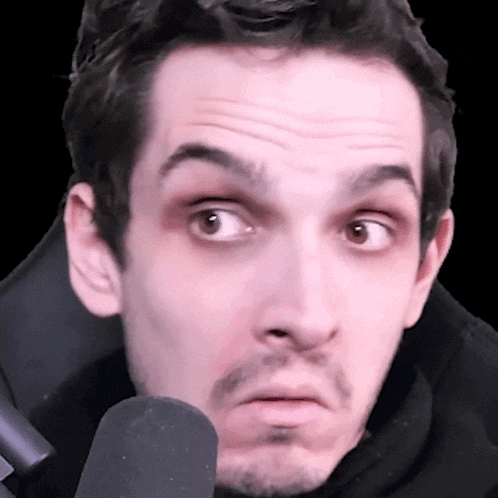 a close up of a man 's face with a microphone in front of him