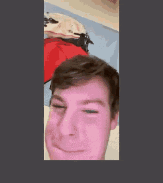 a man is making a funny face in front of a picture of a motorcycle helmet .