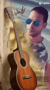 a man leaning against a wall with a guitar and sunglasses on