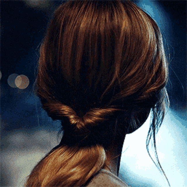 a woman 's hair is in a ponytail with a knot in the middle