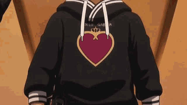 a person is wearing a black hoodie with a red heart on the back