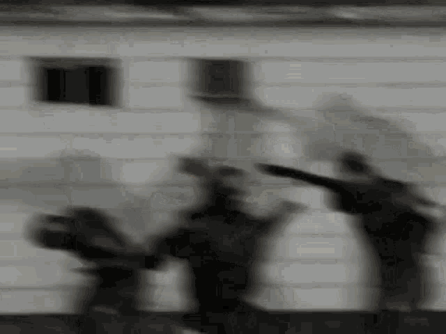 a group of people are dancing in front of a building in a blurry photo .