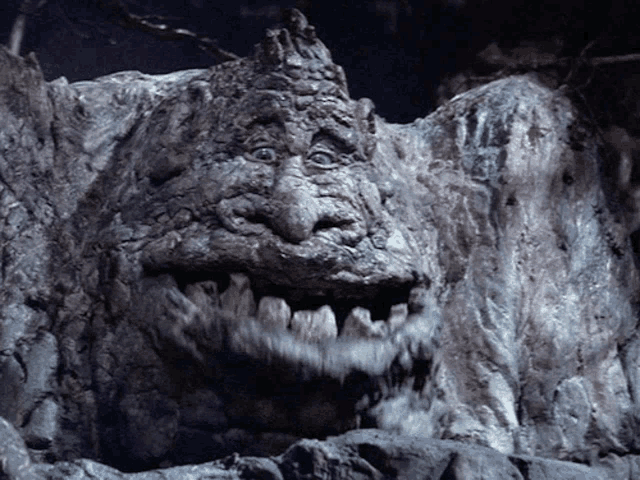 a close up of a tree trunk with a monster face