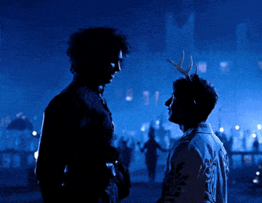 a man with antlers on his head looks at another man