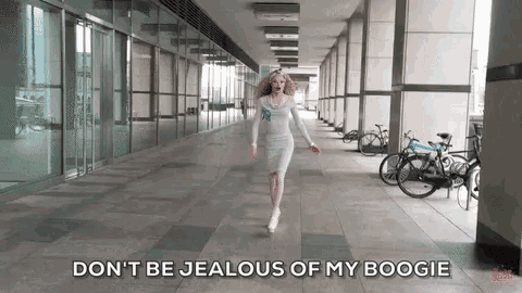 a woman in a white dress is walking down a hallway with bicycles parked on the side .