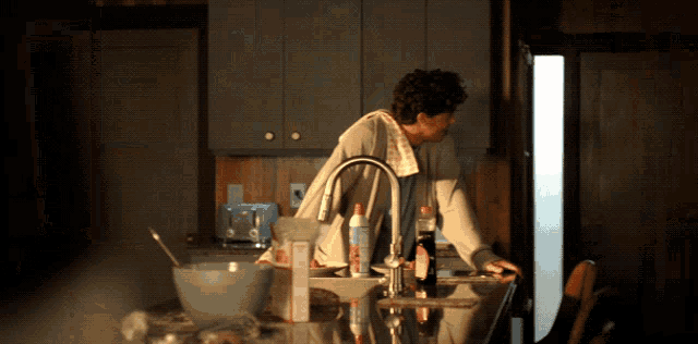a woman standing in a kitchen with a box on the counter that says ' i love you ' on it