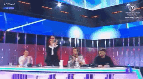 a group of people sitting at a table in front of a screen that says #otgala2 on it