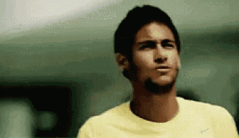 a man in a yellow shirt is standing in a room .