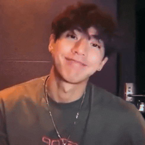 a close up of a young man wearing a t-shirt and a necklace .