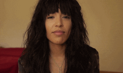 a woman with long black hair and bangs is smiling