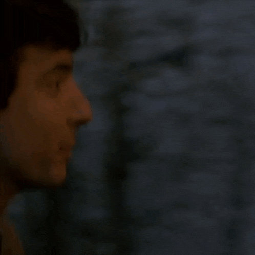 a close up of a man looking out a window .