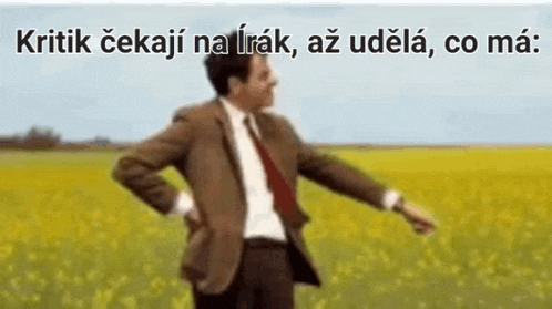 a man in a suit and tie is dancing in a field of yellow flowers .