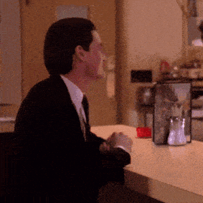 a man in a suit and tie is sitting at a counter in front of a menu