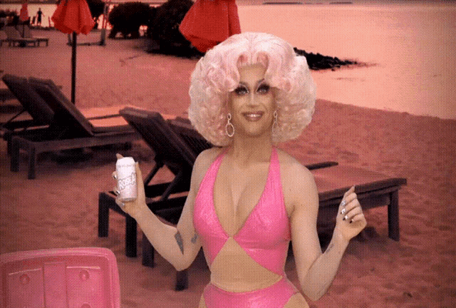 a woman in a pink bathing suit is holding a can of coca cola