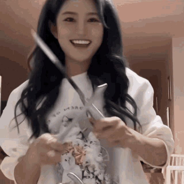 a woman is holding a pair of scissors and a knife