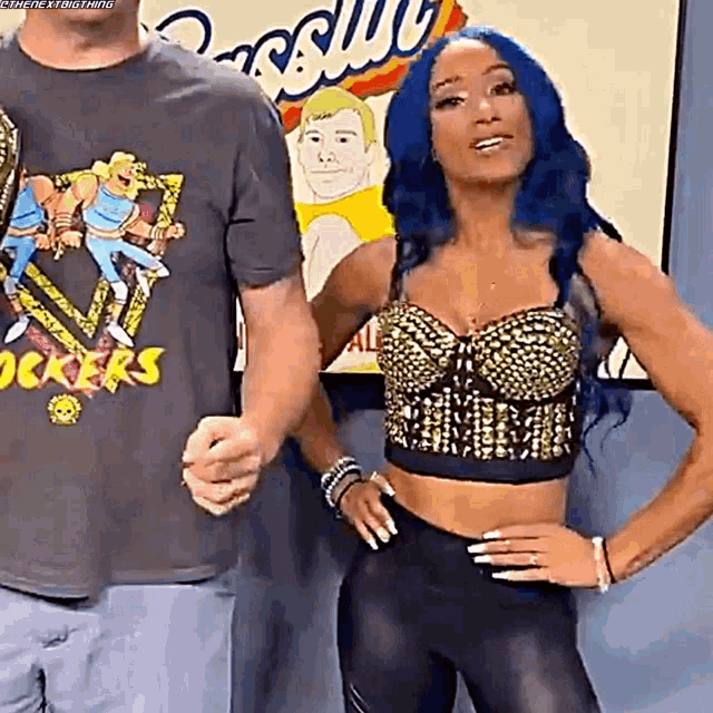 a woman with blue hair is standing next to a man wearing a shirt that says ' rocker ' on it