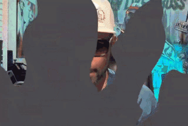 a man wearing sunglasses and a hat with a letter g on it