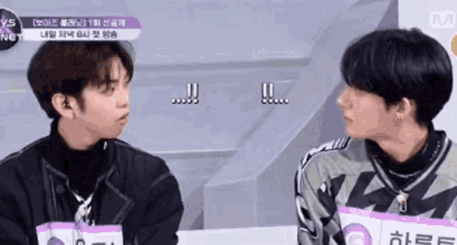 two young men are sitting next to each other and one of them is wearing a name tag that says nct