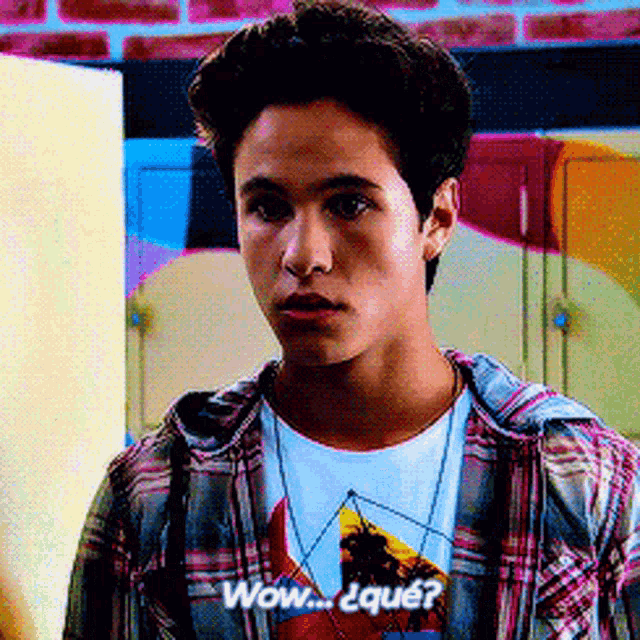 a young man wearing a plaid shirt and a t-shirt that says wow on it