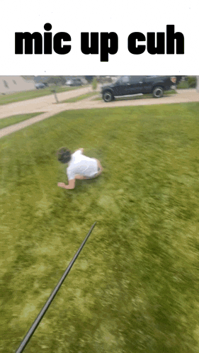 a man is laying on the grass with the words mic up cuh written above him