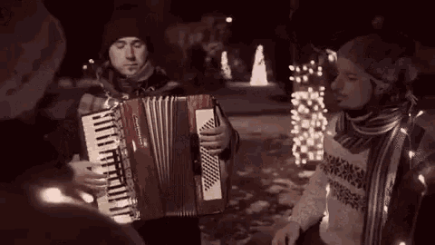 a man is playing an accordion and a man is playing a keyboard .
