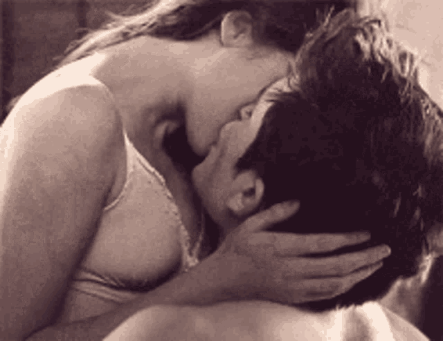 a woman is kissing a man on the forehead in a black and white photo