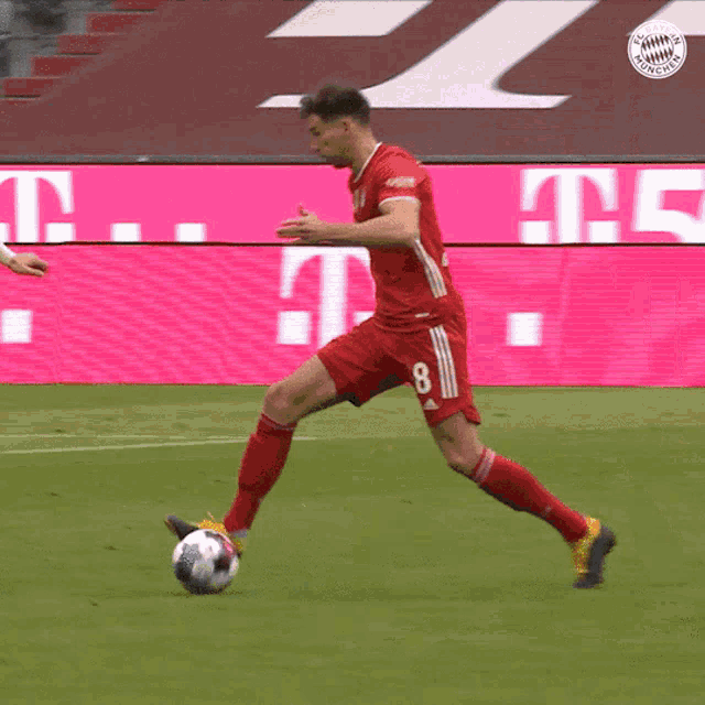 a soccer player with the number 8 on his jersey is kicking a ball