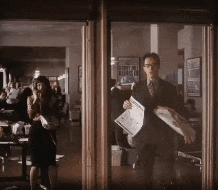 a man in a suit is holding a newspaper in front of a sign that says corny hill