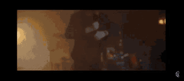 a man is playing drums in a dark room with a microphone in the background .