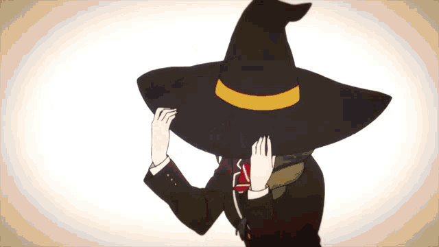a girl wearing a black witch hat with a yellow stripe