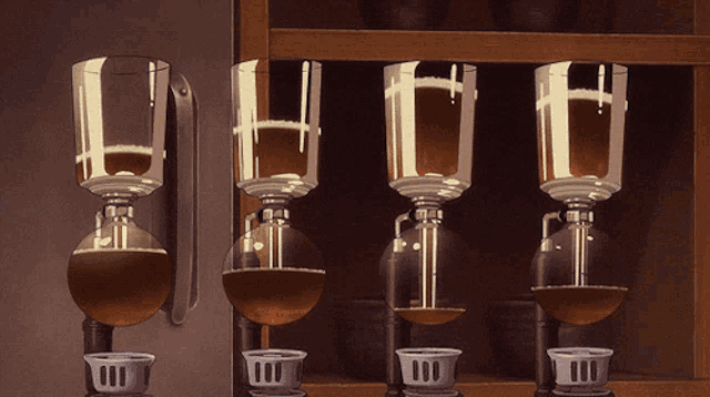 a row of glasses with the letter h on them are lined up on a shelf