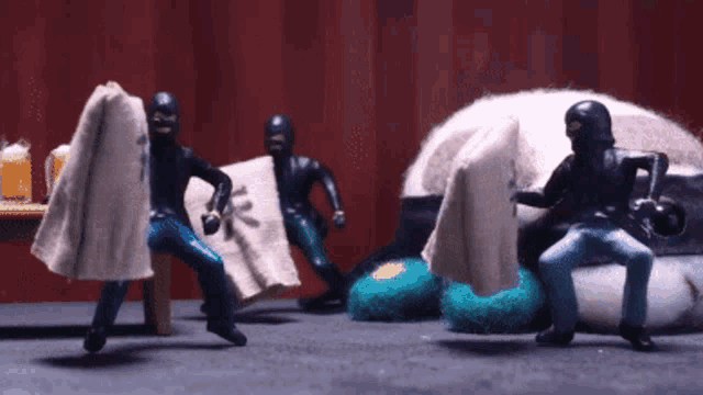 a group of toy figures in black masks are playing with a couch