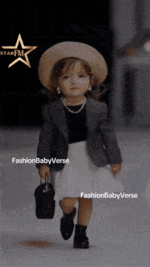 a little girl wearing a hat and holding a purse is walking down a runway