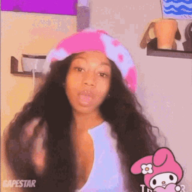 a woman wearing a pink and white hat is standing in front of a mirror .