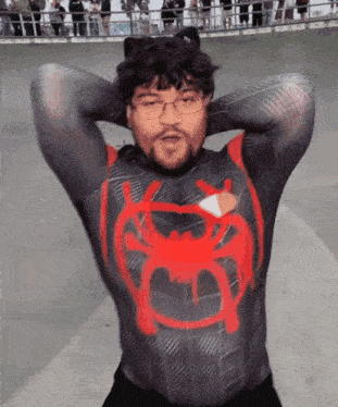 a man wearing a spiderman costume with a red spider on his chest