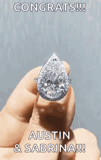 a person is holding a diamond ring with the words congrats austin & sabrina written on it