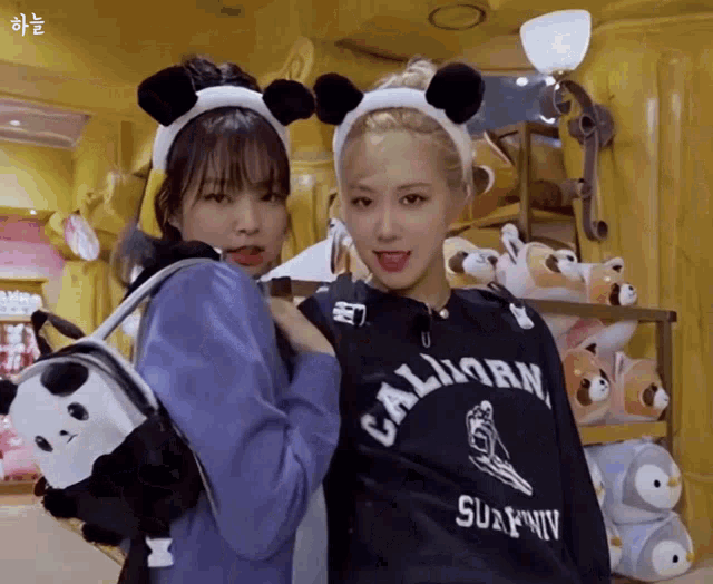 two girls wearing panda ears and a california sweatshirt pose for a picture