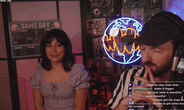 a man and a woman are standing in front of a game day sign