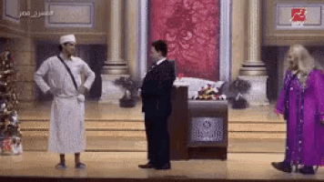 a man in a suit and a woman in a purple dress stand on a stage .