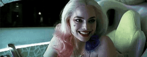 a woman in a suicide squad costume is smiling and sitting in a car .