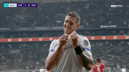 a soccer player wearing a shirt that says ' aksa ' on the sleeve