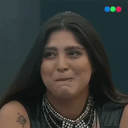 a woman with a tattoo on her arm is making a silly face