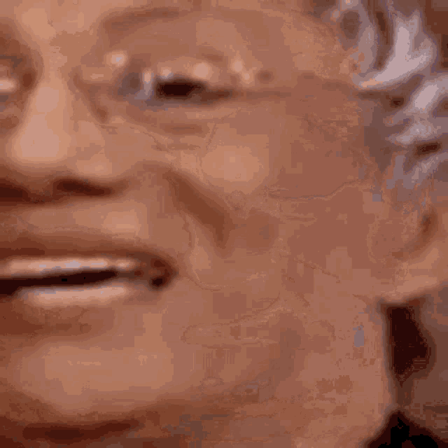 a close up of a person 's face with glasses and a smile .