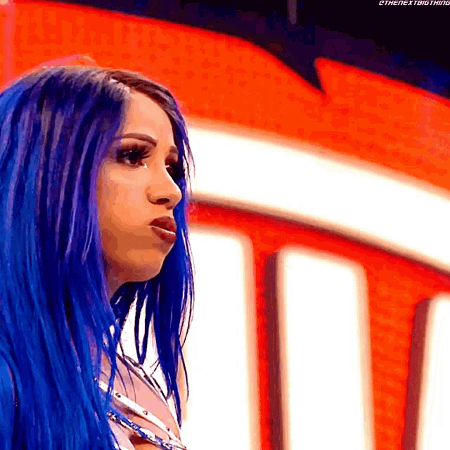 a woman with blue hair is standing in front of a red and white sign