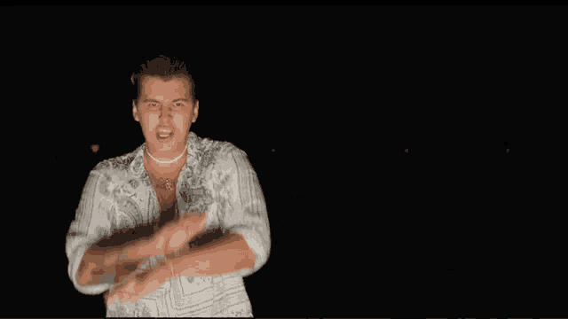 a man in a white shirt with a necklace that says " i love you " on it