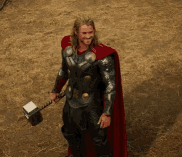 a man in armor holding a hammer in a field
