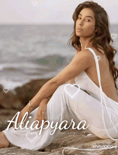 a woman in a white dress is sitting on a rock near the ocean with the name aliapyara written on the bottom